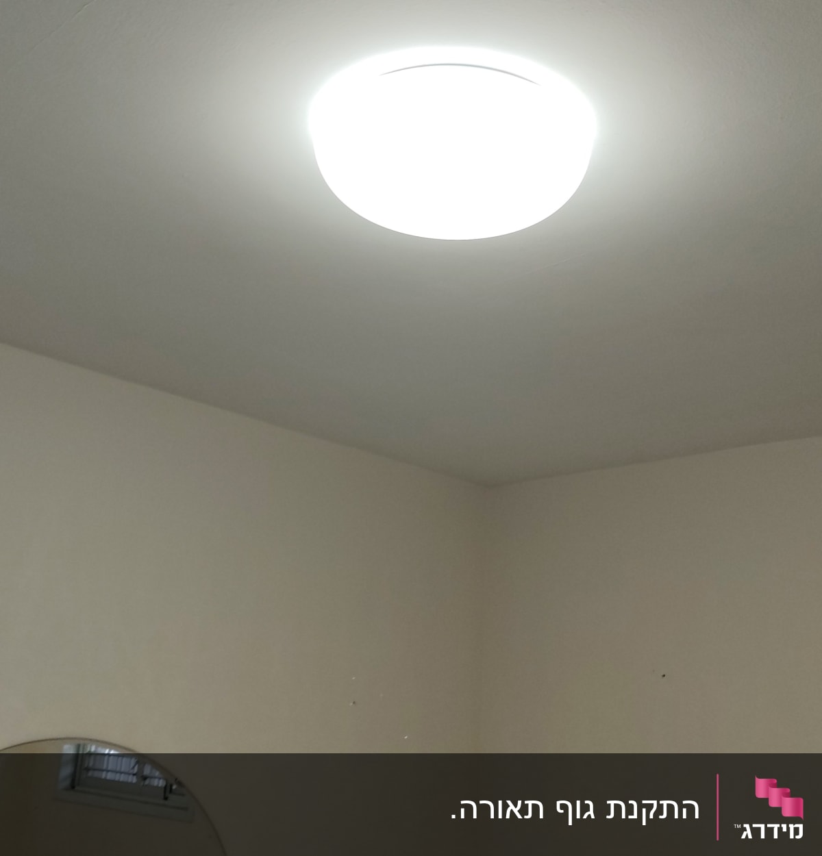 מנורת תקרה עגולה דולקת על תקרה לבנה